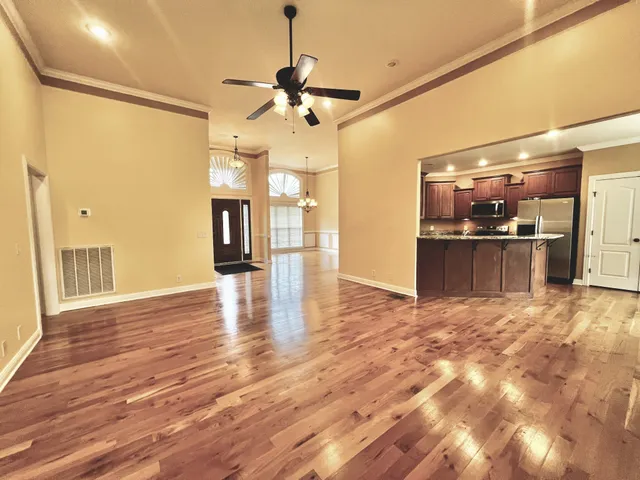 a view of a livingroom with a ceiling fan and wooden floor