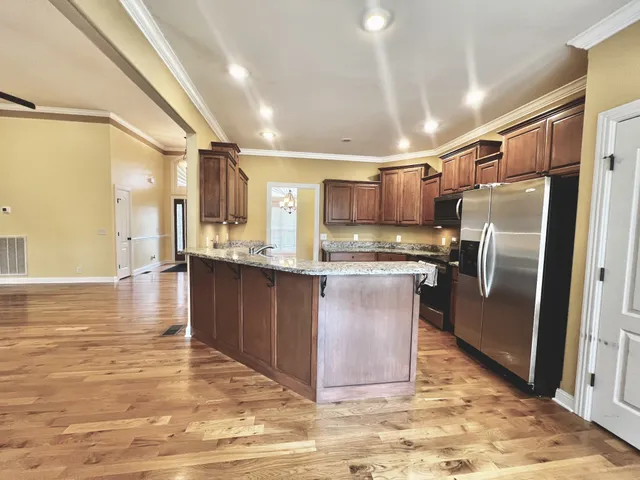 a view of a livingroom with wooden floor and a ceiling fan