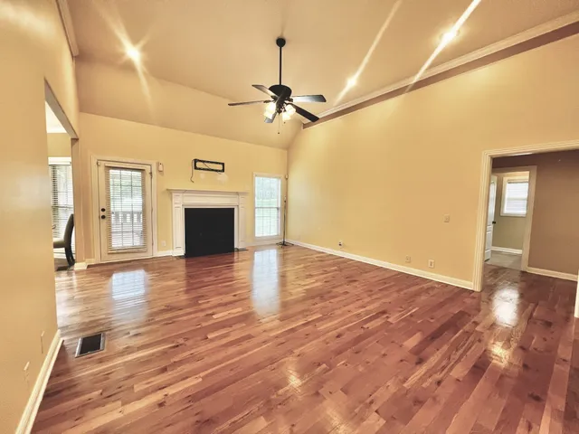 a view of a hallway with wooden floor and staircase
