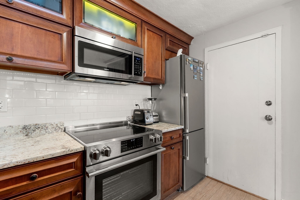 31 Warren Street, Unit B1 Waltham, MA 02453 - Photo 7 of 22 a kitchen with stainless steel appliances a stove and a microwave