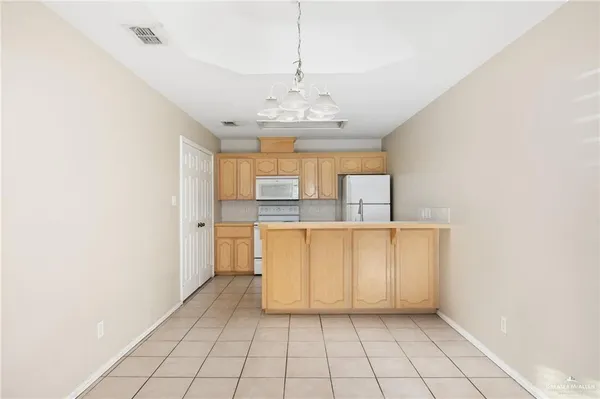 a view of kitchen with granite countertop cabinets and window