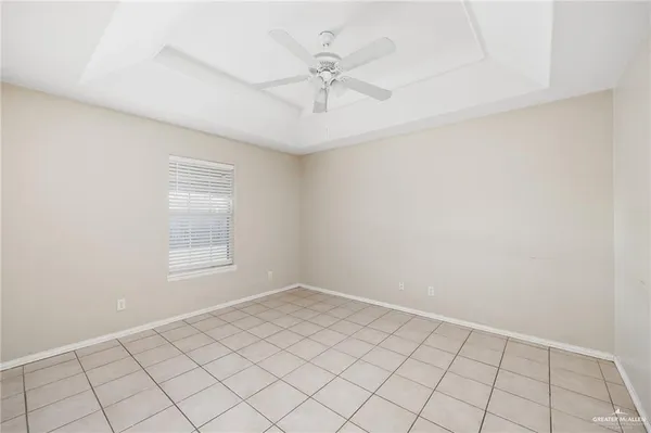 an empty room with windows and ceiling fan