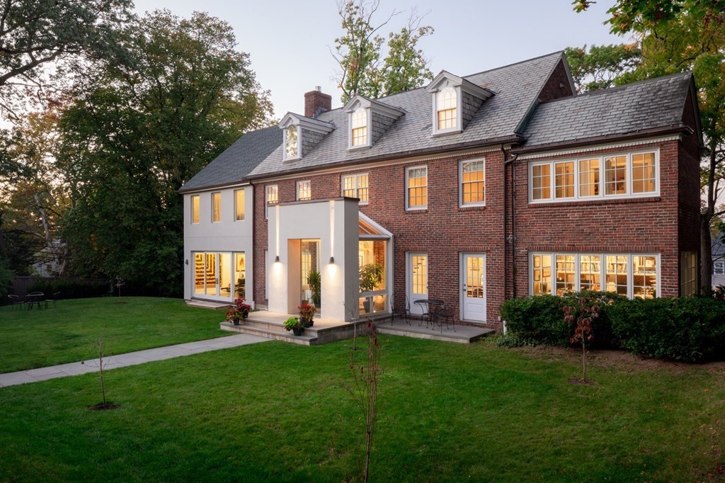 a front view of a house with a yard and outdoor seating