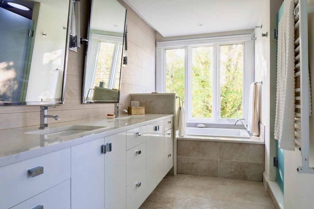 185 Franklin Street Newton, MA 02458 - Photo 13 of 23 a bathroom with a granite countertop sink a mirror and a bathtub