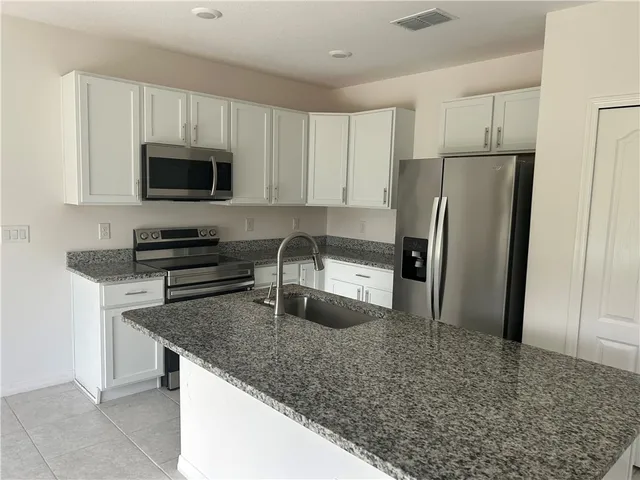 a kitchen with a refrigerator stove and microwave