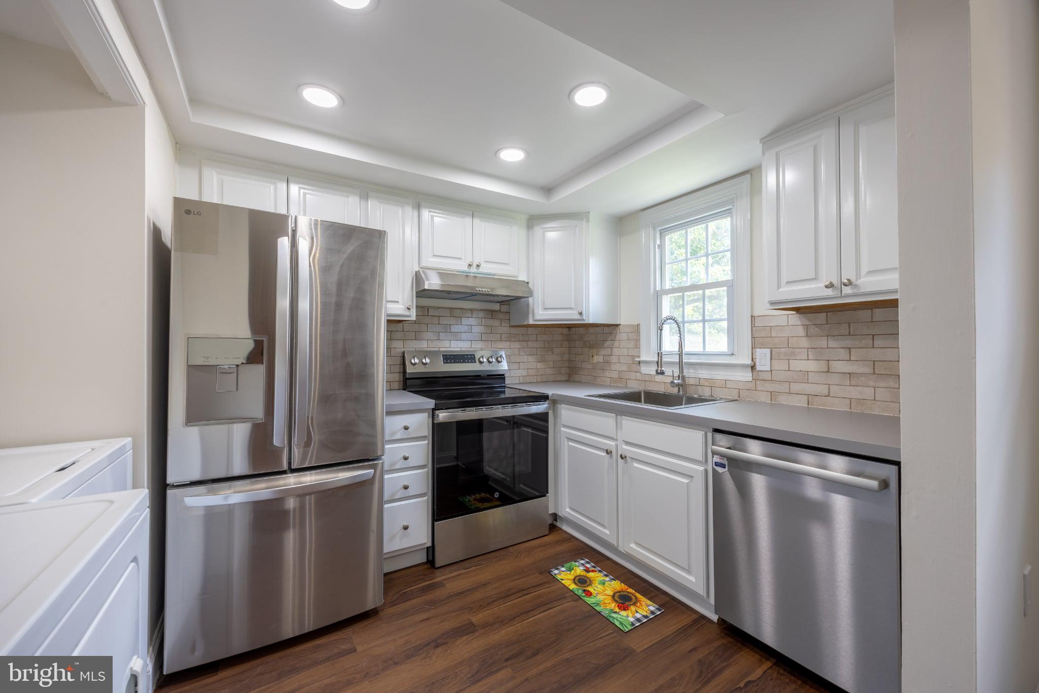 207 Yardley Commons Yardley, PA 19067 - Photo 4 of 19 a kitchen with granite countertop stainless steel appliances a refrigerator cabinets and wooden floor