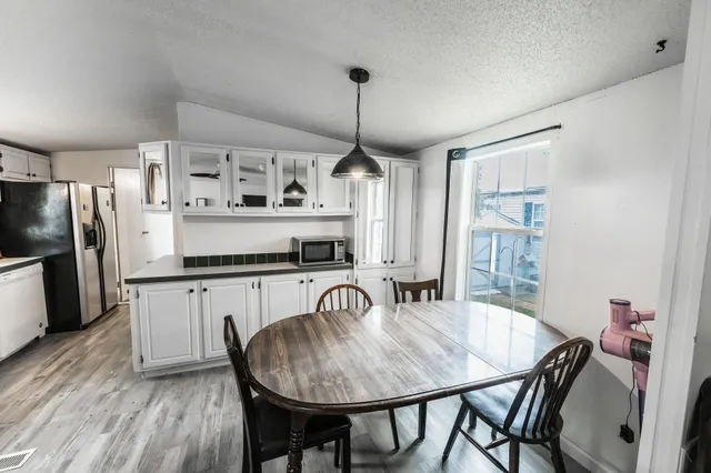 a kitchen with stainless steel appliances granite countertop a kitchen island hardwood floor sink stove dining table and chairs