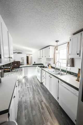 a kitchen with stainless steel appliances a sink a stove top oven a counter space and cabinets