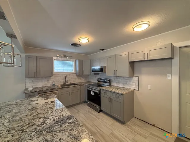 a kitchen with a stove a sink and a refrigerator