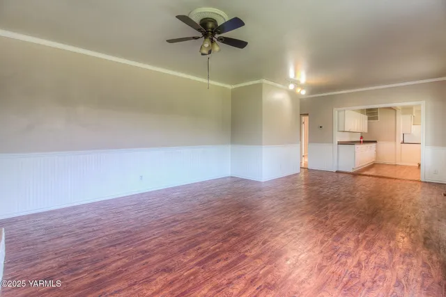 a view of a room with wooden floor and a ceiling fan