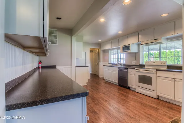 a kitchen with stainless steel appliances a stove top oven a sink and a refrigerator