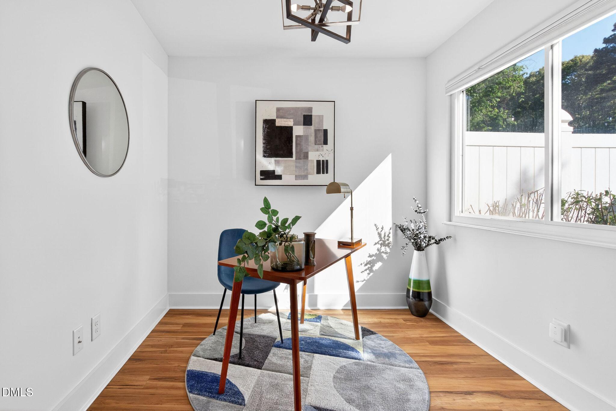 7149 Sandy Creek Drive Raleigh, NC 27615 - Photo 6 of 23 a room with painting on the wall and a potted plant