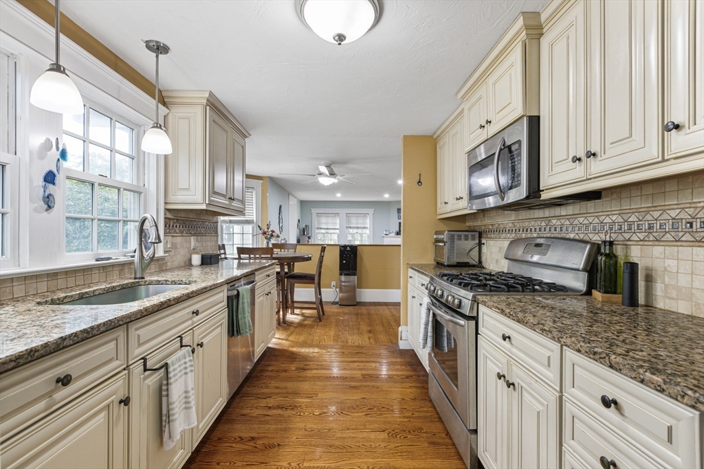 380 North Main Street Sharon, MA 02067 - Photo 10 of 35 a large kitchen with stainless steel appliances granite countertop a stove top oven a sink dishwasher and a microwave oven with white cabinets