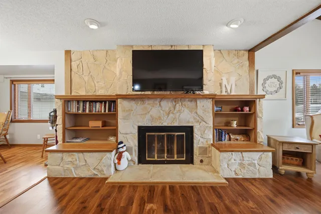 a living room with furniture a flat screen tv and a fireplace
