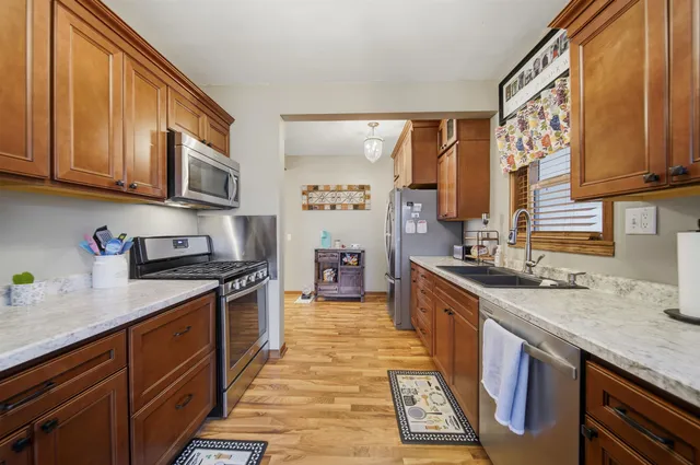 a large kitchen with stainless steel appliances granite countertop a stove a sink and a microwave