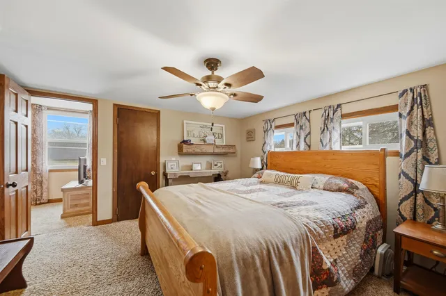 a bedroom with a large bed a chandelier and a dresser