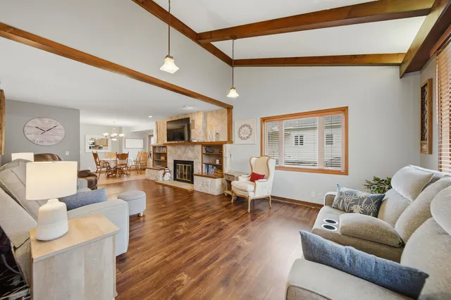 a living room with furniture kitchen view and a wooden floor