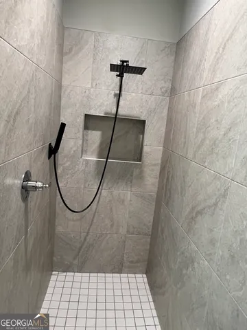 a bathroom with a granite countertop sink a large mirror and a shower