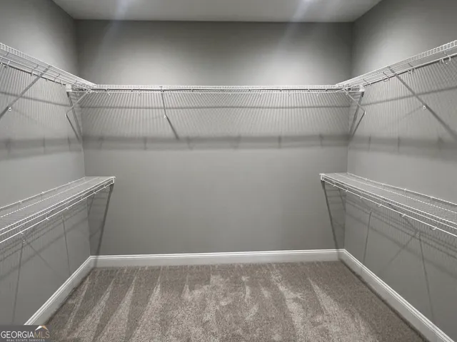 a view of an empty room with wooden floor and cabinets