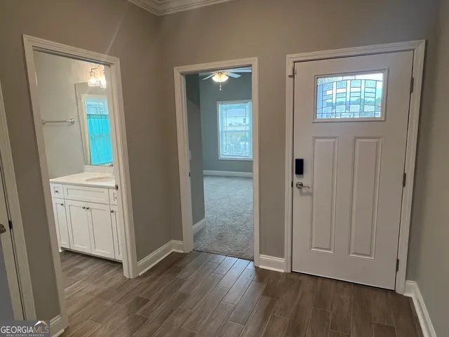 an empty room with wooden floor closet and windows
