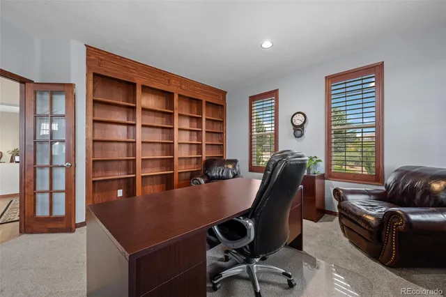 a view of a workspace with furniture and a window