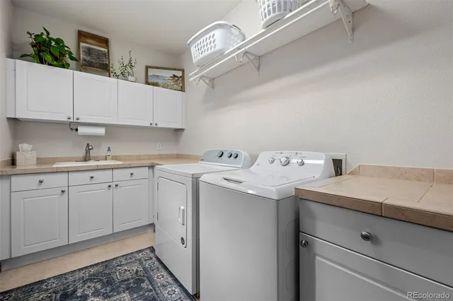 a utility room with cabinets washer and dryer