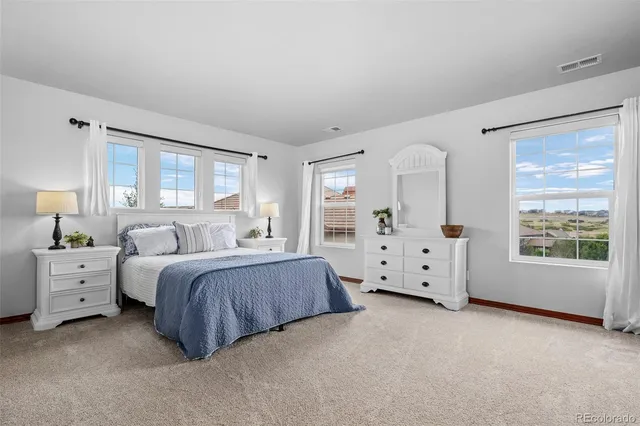 a spacious bedroom with a bed and a large window