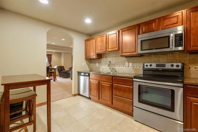 a kitchen with stainless steel appliances granite countertop a stove microwave and sink
