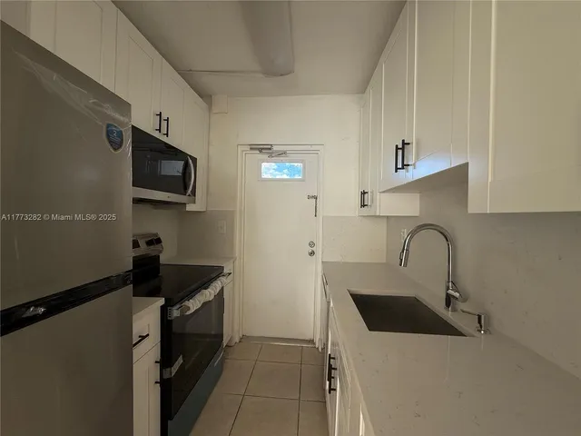 a kitchen with a sink a stove and cabinets