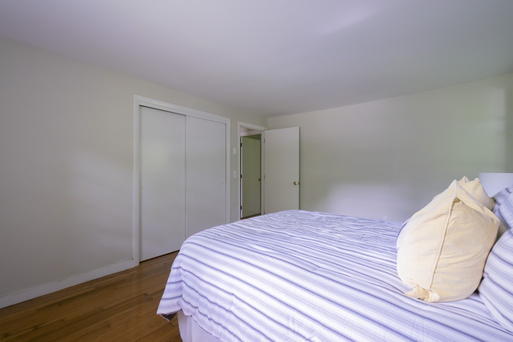 75 Reed Street Lexington, MA 02421 - Photo 23 of 30 a bedroom with a bed and wooden floor