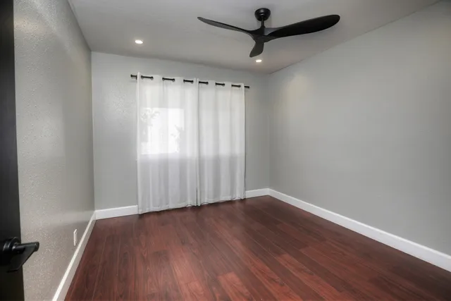 a view of an empty room with wooden floor
