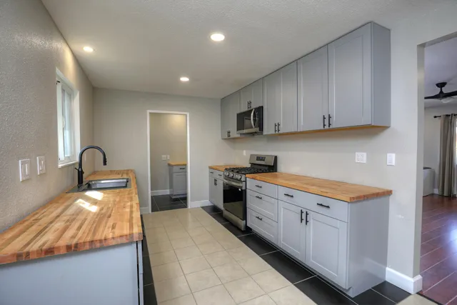 a kitchen with stainless steel appliances granite countertop a stove a sink and a refrigerator