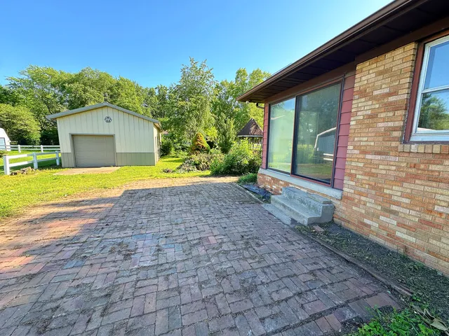 a view of yellow house with a yard and large tree