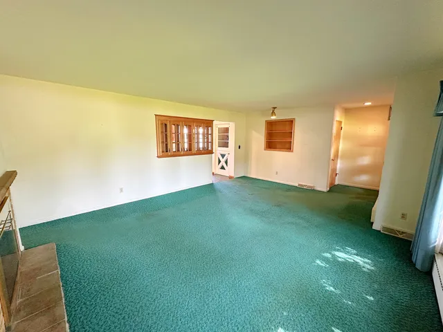 a view of an empty room with kitchen
