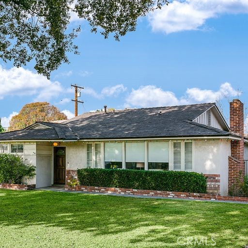a front view of a house with a garden and yard