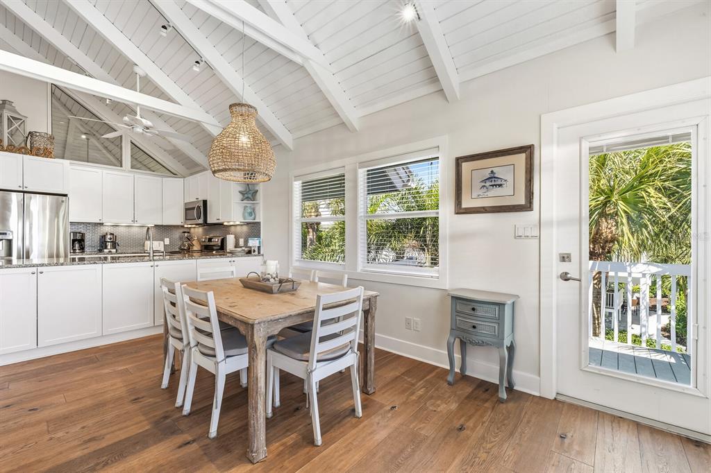 5000 Gasparilla Road, Unit 19 Boca Grande, FL 33921 - Photo 8 of 48 a dining room with stainless steel appliances granite countertop a kitchen island hardwood floor and a large window
