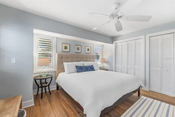 a bedroom with a large bed chandelier and a window