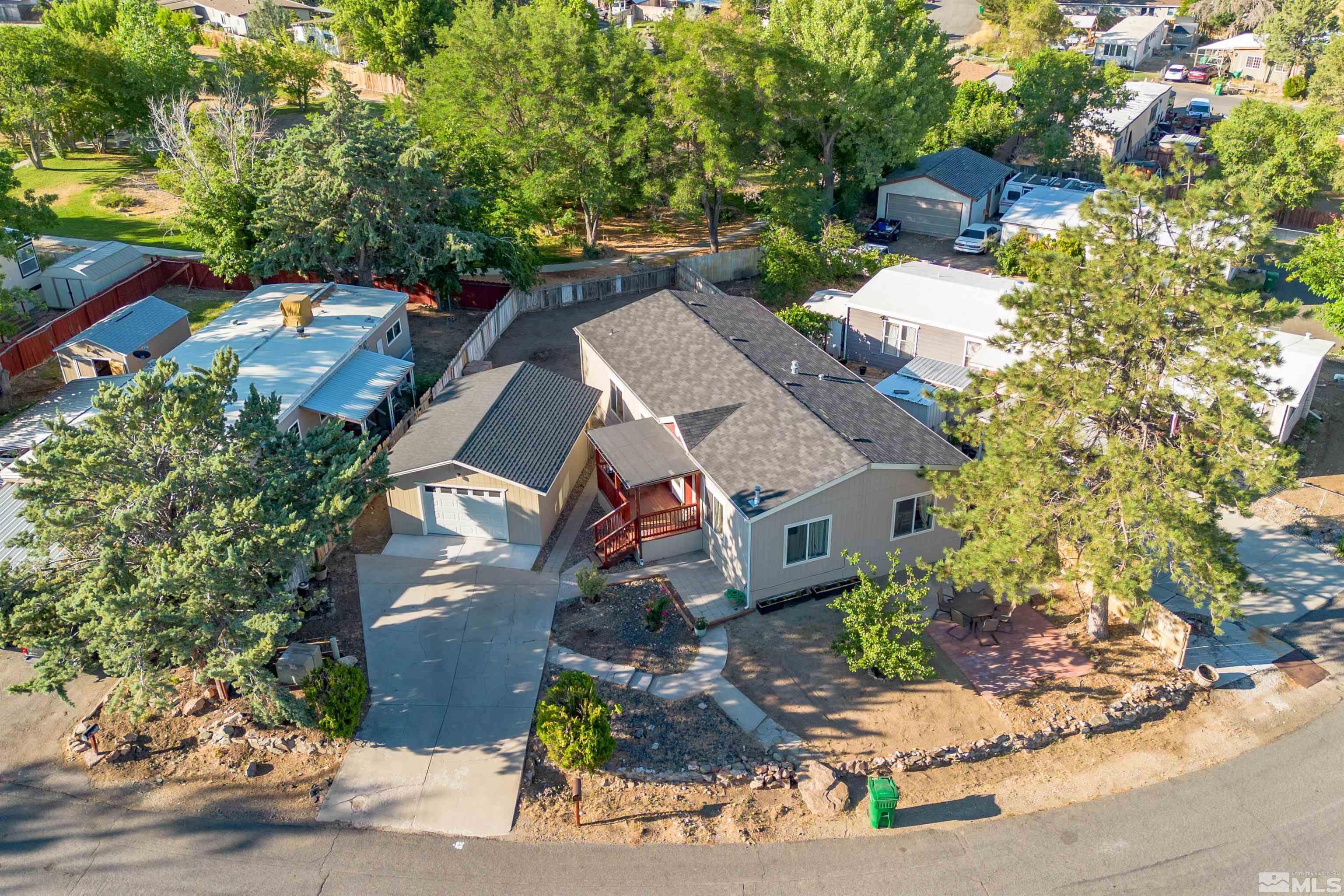 an aerial view of a house with a yard and a large tree