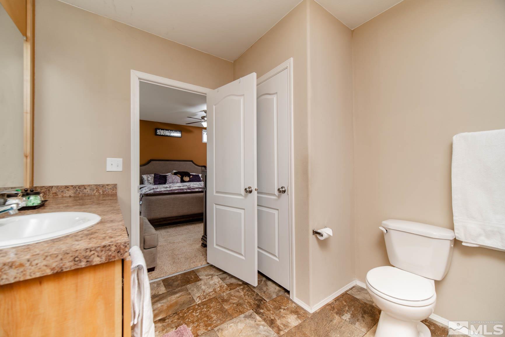 16210 Rhyolite Circle Reno, NV 89521 - Photo 17 of 39 a bathroom with a granite countertop sink toilet and shower