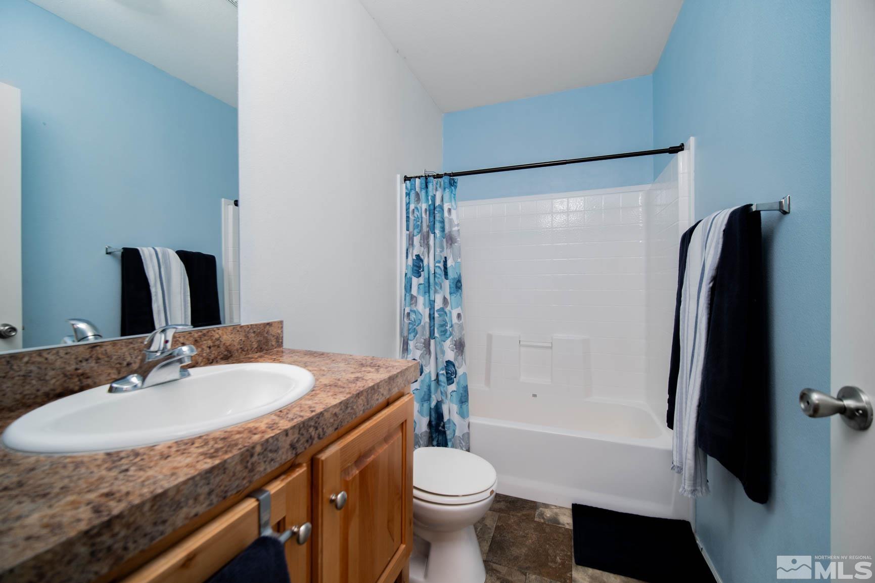 16210 Rhyolite Circle Reno, NV 89521 - Photo 19 of 39 a bathroom with a granite countertop sink toilet and shower