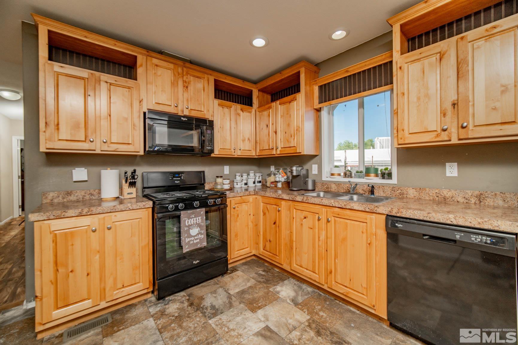 16210 Rhyolite Circle Reno, NV 89521 - Photo 10 of 39 a kitchen with stainless steel appliances granite countertop a stove sink microwave and cabinets