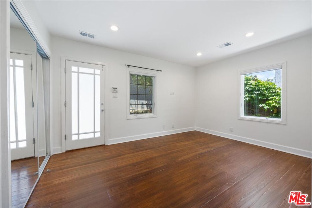14041 Roblar Road Sherman Oaks, CA 91423 - Photo 29 of 47 an empty room with wooden floor and windows
