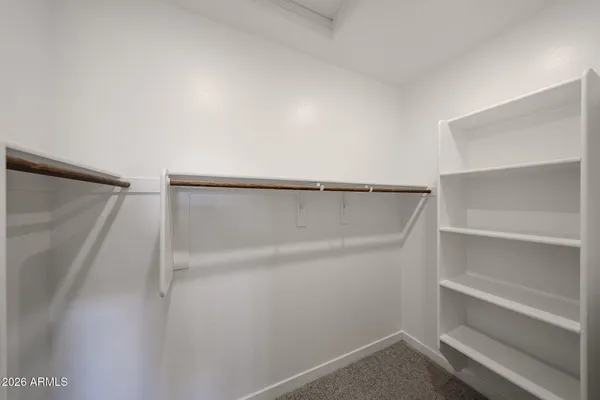 a view of walk in closet with empty racks