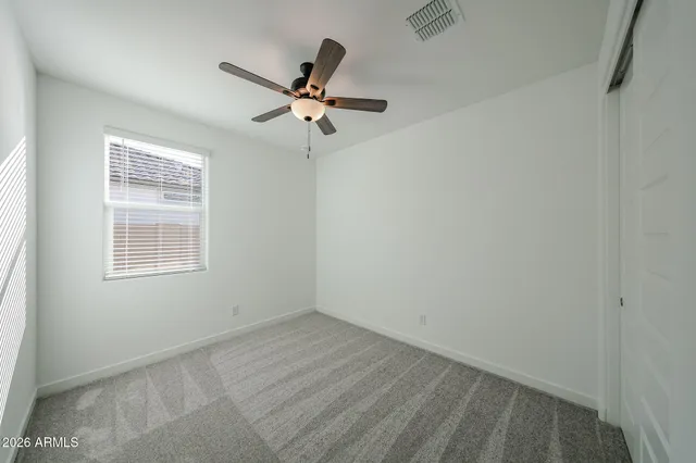 an empty room with a window and a fan
