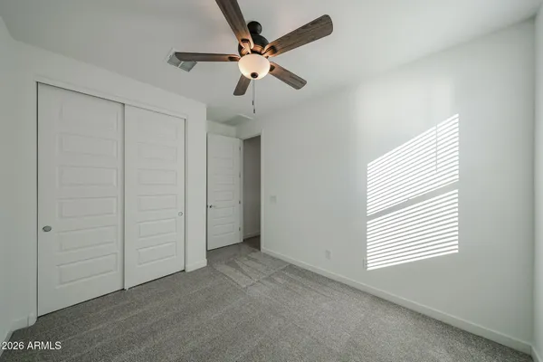 an empty room with a ceiling fan and window