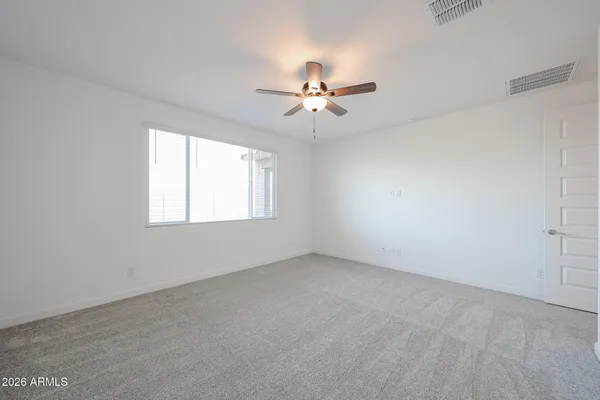 an empty room with windows and fan