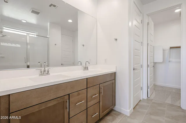 a bathroom with a double vanity sink mirror and shower