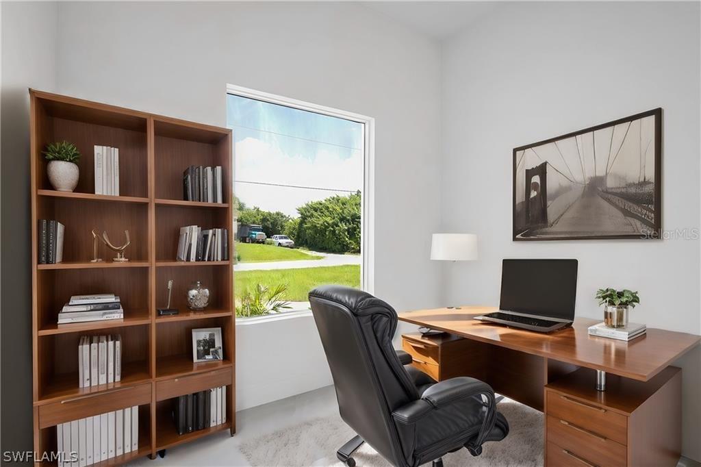 2921 7th Street Southwest Lehigh Acres, FL 33976 - Photo 4 of 8 a workspace with furniture and a book shelf