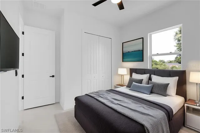 a bedroom with a large bed and a flat tv screen on dresser