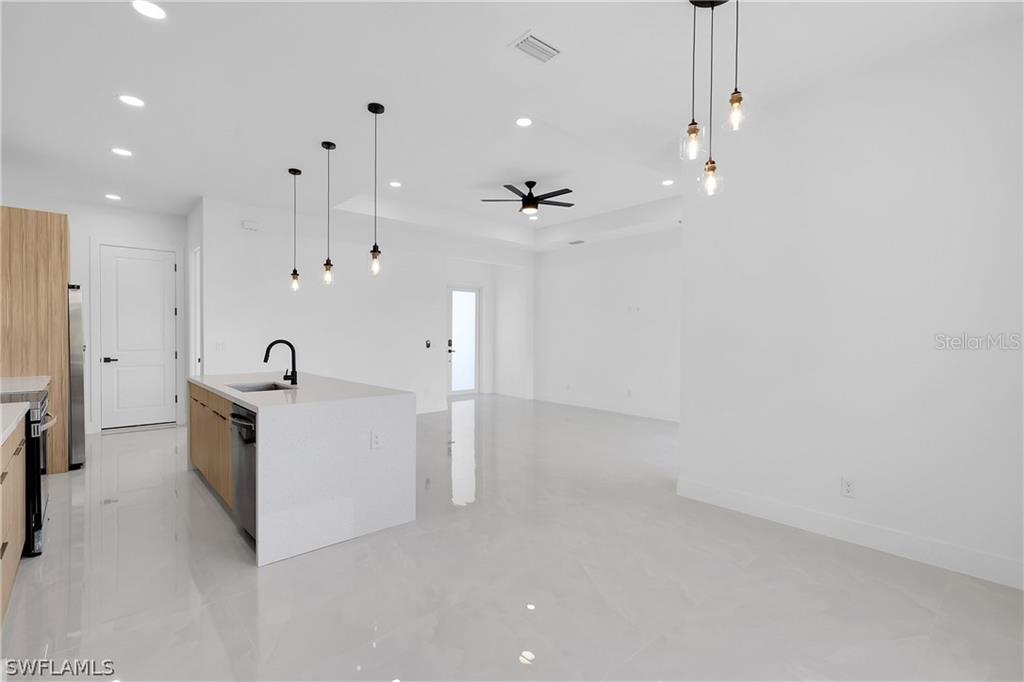 2921 7th Street Southwest Lehigh Acres, FL 33976 - Photo 6 of 8 a large white kitchen with cabinets and a sink